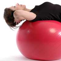 Frau liegt auf einem Gymnastikball